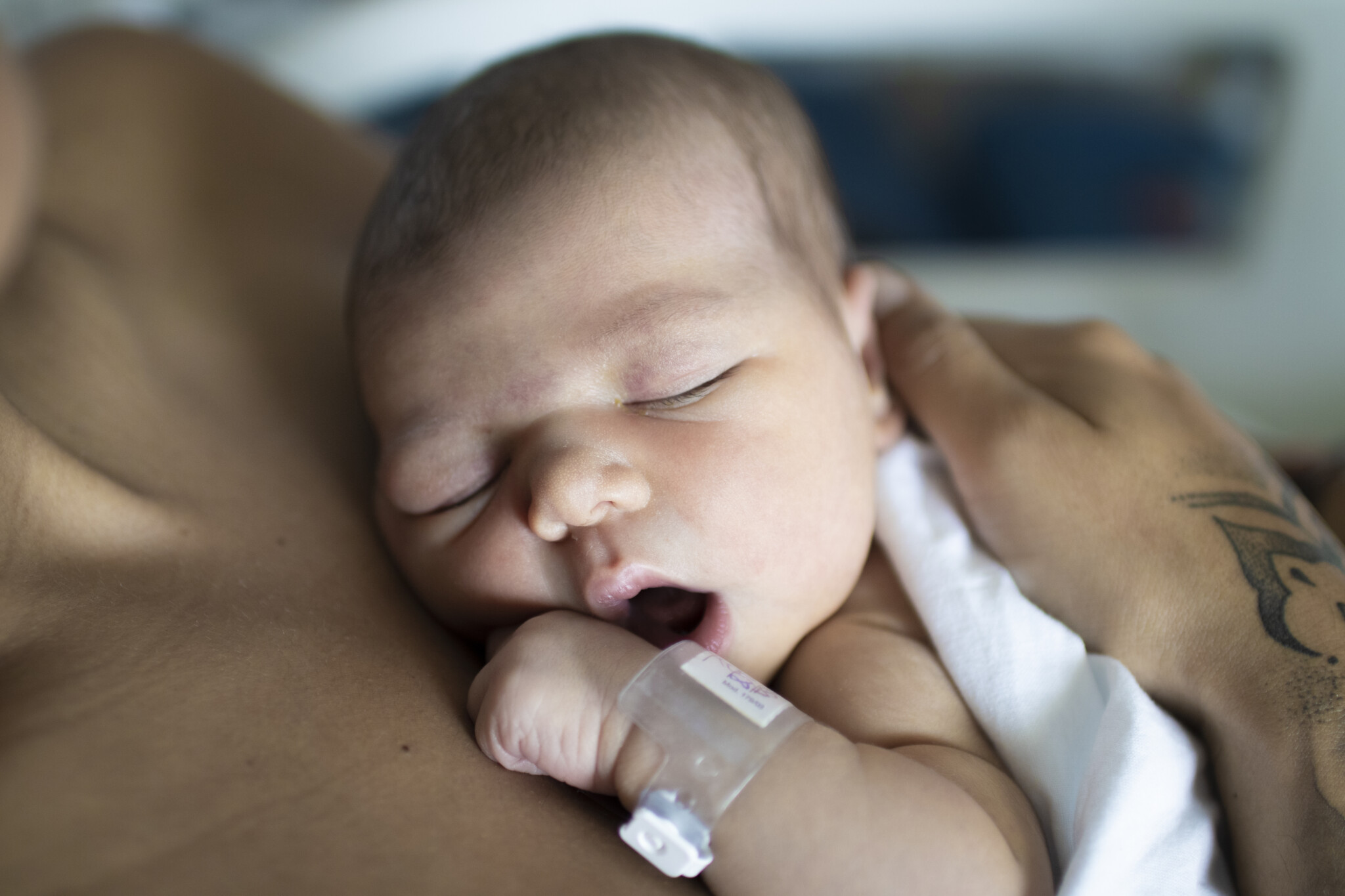 Baby with mouth open and laying on mother's chest