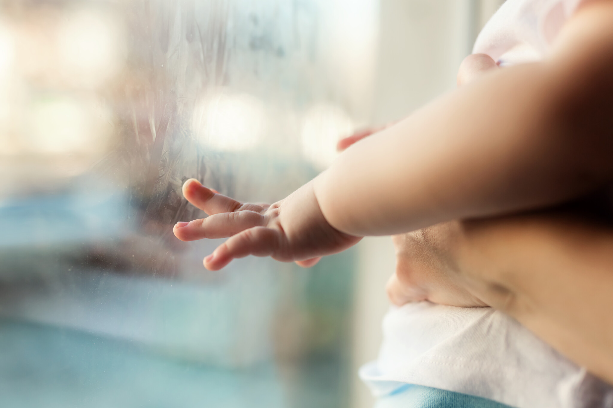 A child's little hand on the window glass