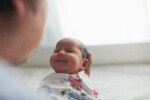 Father holding newborn daughter smiling