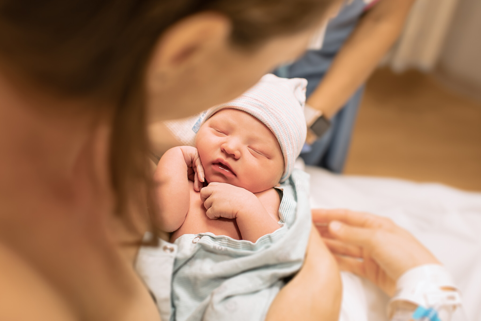 newborn baby girl sleeping in mothers arms