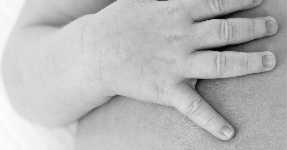 Up close of baby hand on chest